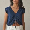 Camiseta azul marino con volantes en los hombros y frunce en el pecho