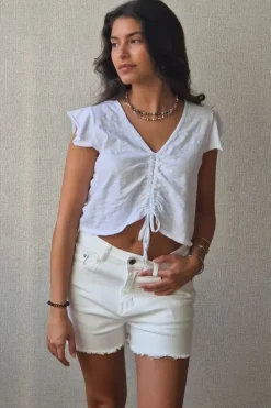 Camiseta blanca con volantes en los hombros y frunce en el pecho