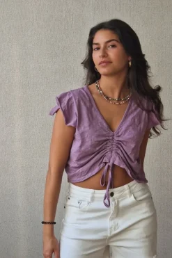 Camiseta lila con volantes en los hombros y frunce en el pecho