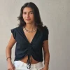 Camiseta negra con volantes en los hombros y frunce en el pecho