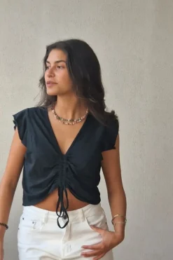 Camiseta negra con volantes en los hombros y frunce en el pecho