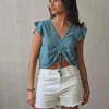 Camiseta verde con volantes en los hombros y frunce en el pecho