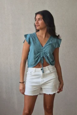 Camiseta verde con volantes en los hombros y frunce en el pecho