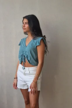 Camiseta verde con volantes en los hombros y frunce en el pecho