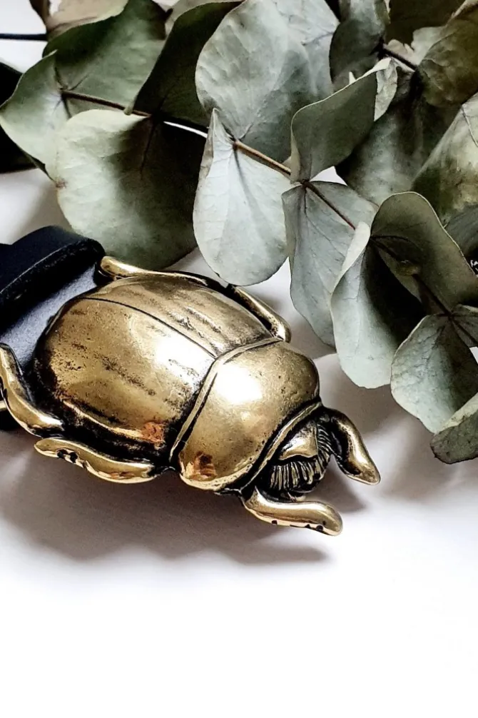 Cinturón de piel negra con hebilla escarabajo