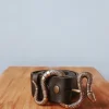 Cinturón de piel negro con hebilla serpiente
