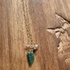 Collar dorado con cuerno pequeño verde