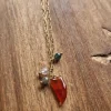 Collar dorado con cuerno pequeño granate