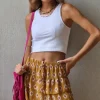 Minifalda pantalón estampada y volantes mostaza