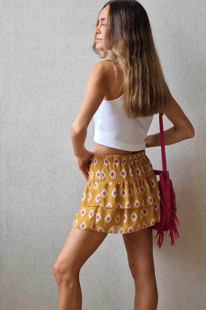 Minifalda pantalón estampada y volantes mostaza