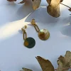 Pendientes dorados de acero y nacar con detalle sol