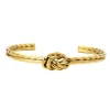 Pulsera rígida con nudo de acerodorada