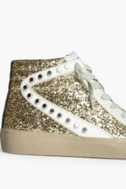 Sneakers dorada con detalle blanco, glitter y tachuelas